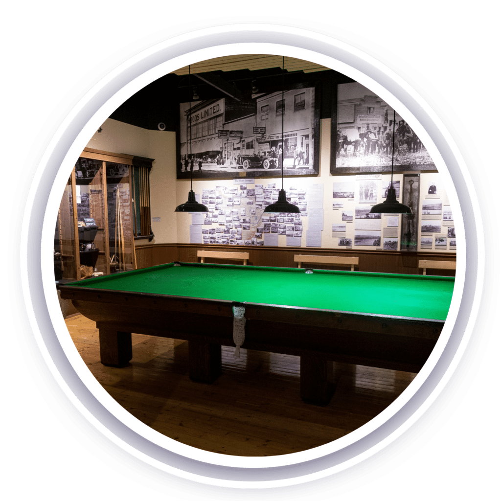 A large billiards table surrounded by historical photos