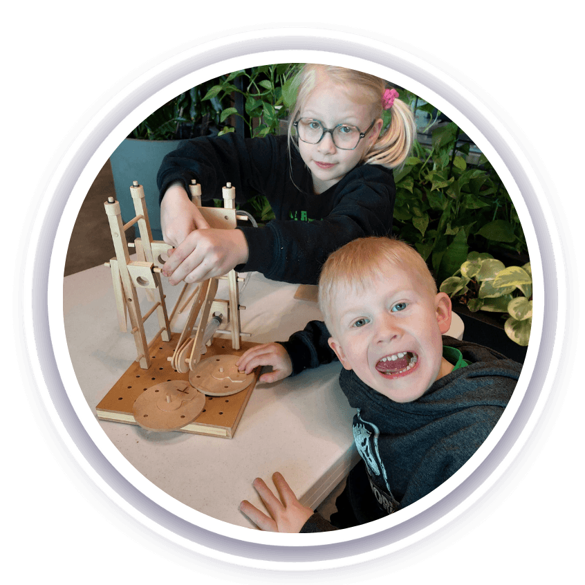 Two kids playing with wooden hydraulics toys